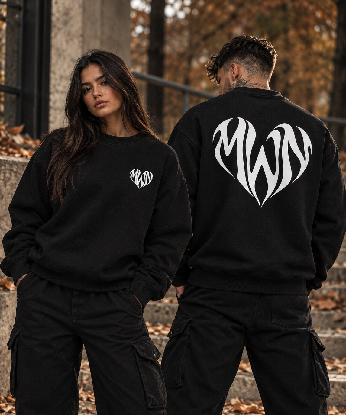 Sweat noir unisexe MWN HEART porté par deux mannequins, logo cœur blanc visible de face et de dos.